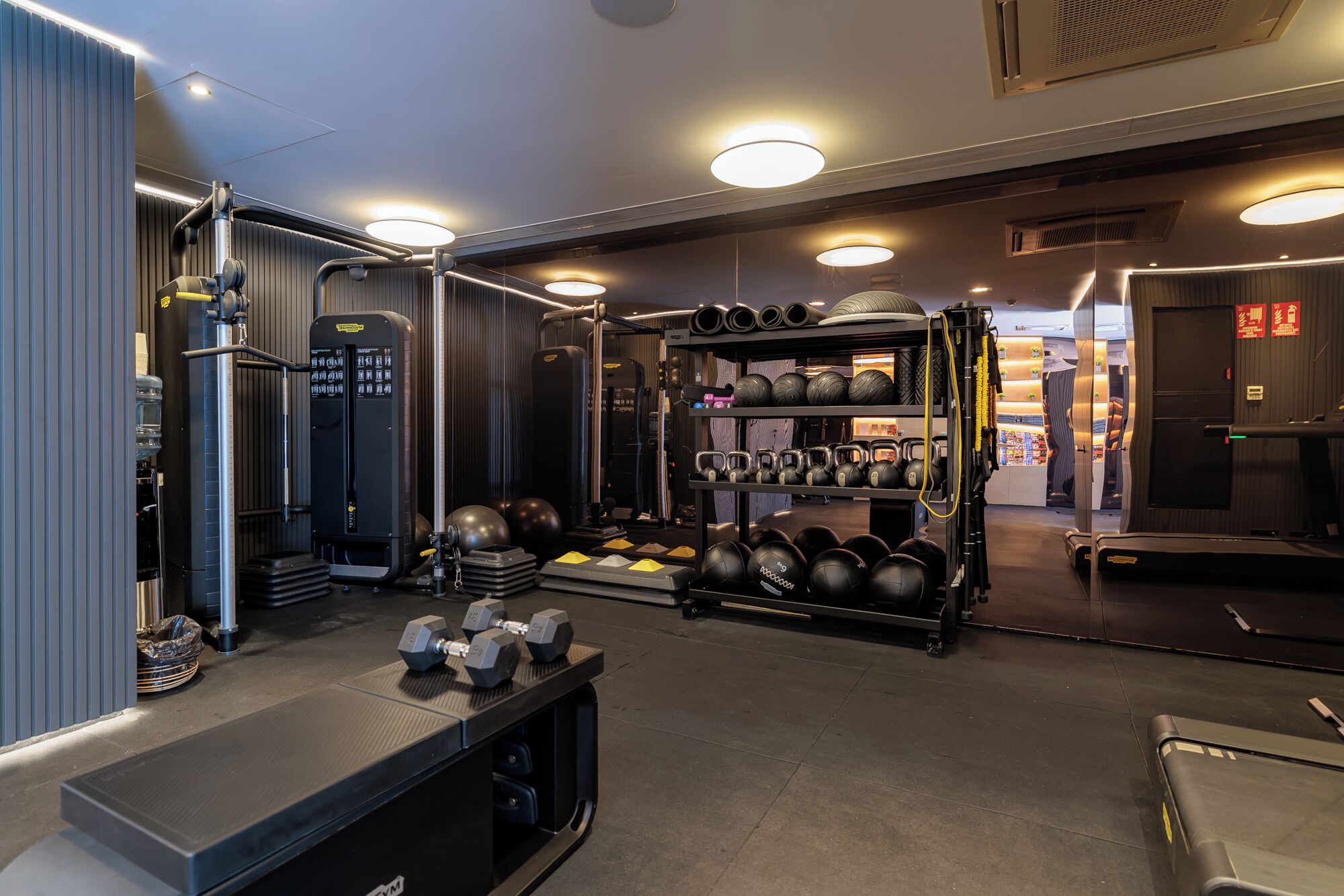 A gym with weightlifting equipment, treadmills, and exercise balls.
