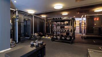A gym with weightlifting equipment, treadmills, and exercise balls.
