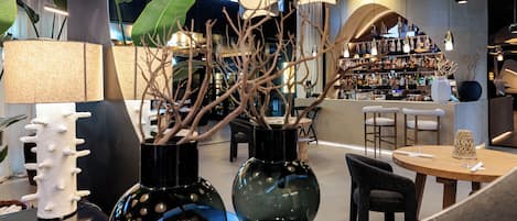 A modern interior with round tables, chairs, and decorative vases.
