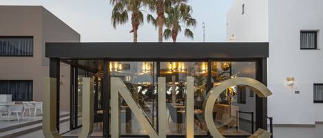 A modern building with a glass entrance and large letters spelling "UNIC".