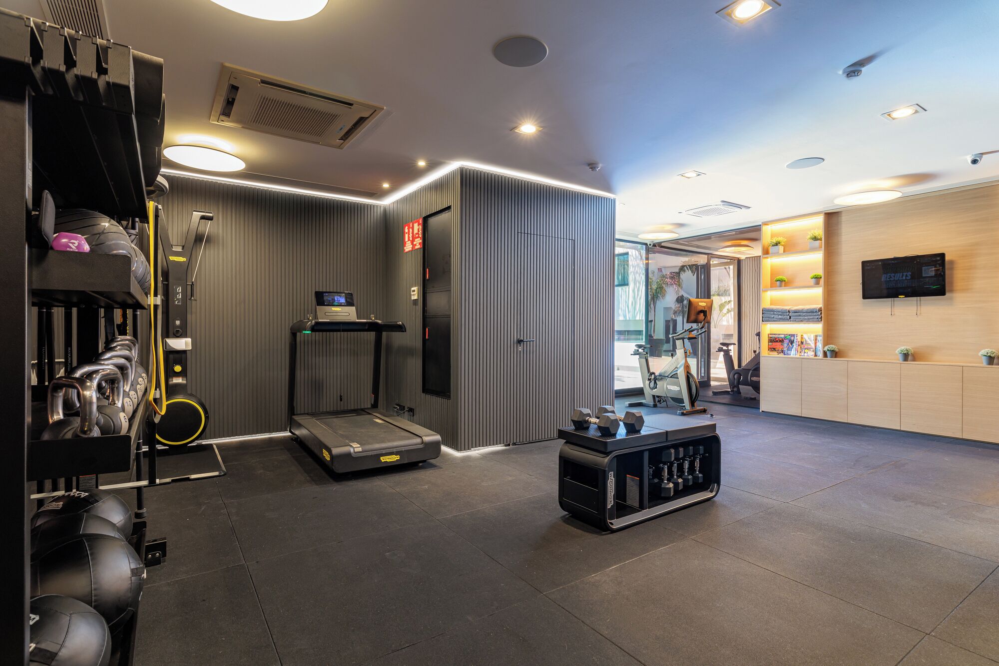 A gym with treadmills, dumbbells, and exercise balls.