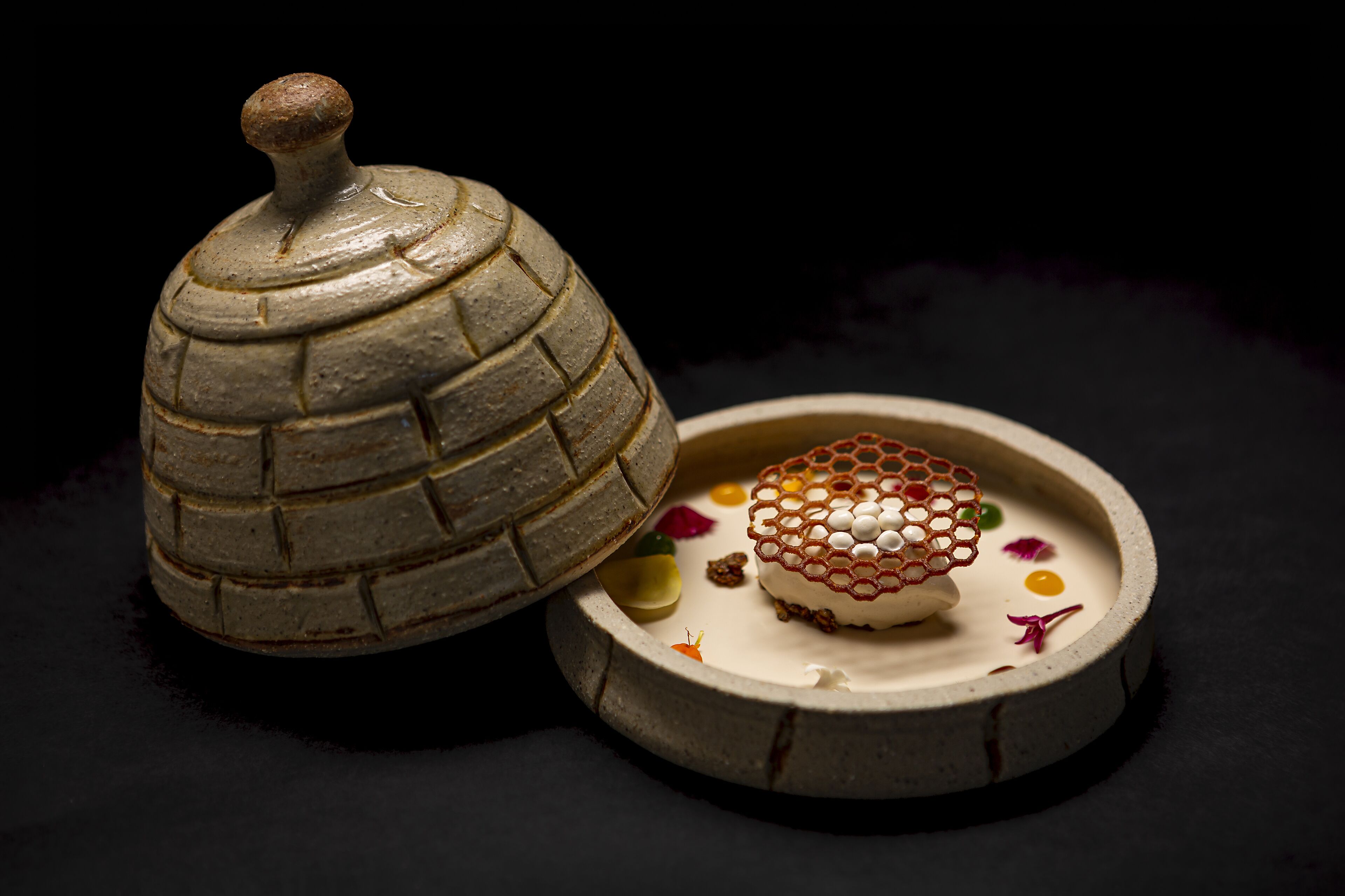 A ceramic dome lid and a decorative plate with a floral arrangement.