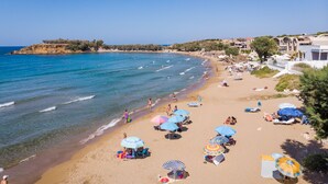 A beach with umbrellas, sun loungers, and people. - Athina Luxury Villas (Platanias)