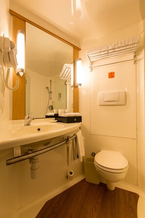 A bathroom with a sink, mirror, towel rack, and toilet.