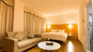 A hotel room with a sofa, a bed, a bedside table, and a round coffee table. - ibis Dongguan Dongcheng (Dongguan)
