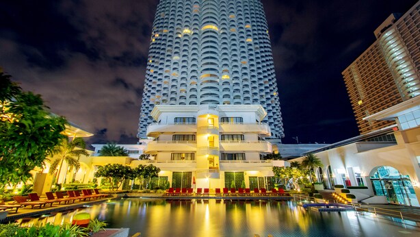 A hotel with a large pool, multiple balconies, and a well-lit facade. - D Varee Jomtien Beach (Pattaya)