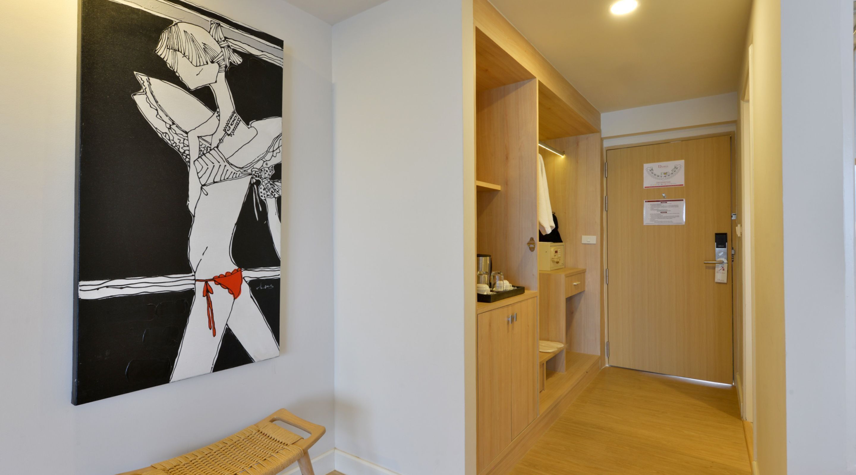A hallway with a wooden door, a bench, and a wall-mounted artwork.