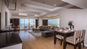 A spacious living area with a dining table set for six, a sofa, and a kitchen area with a countertop. - D Varee Jomtien Beach (Pattaya)