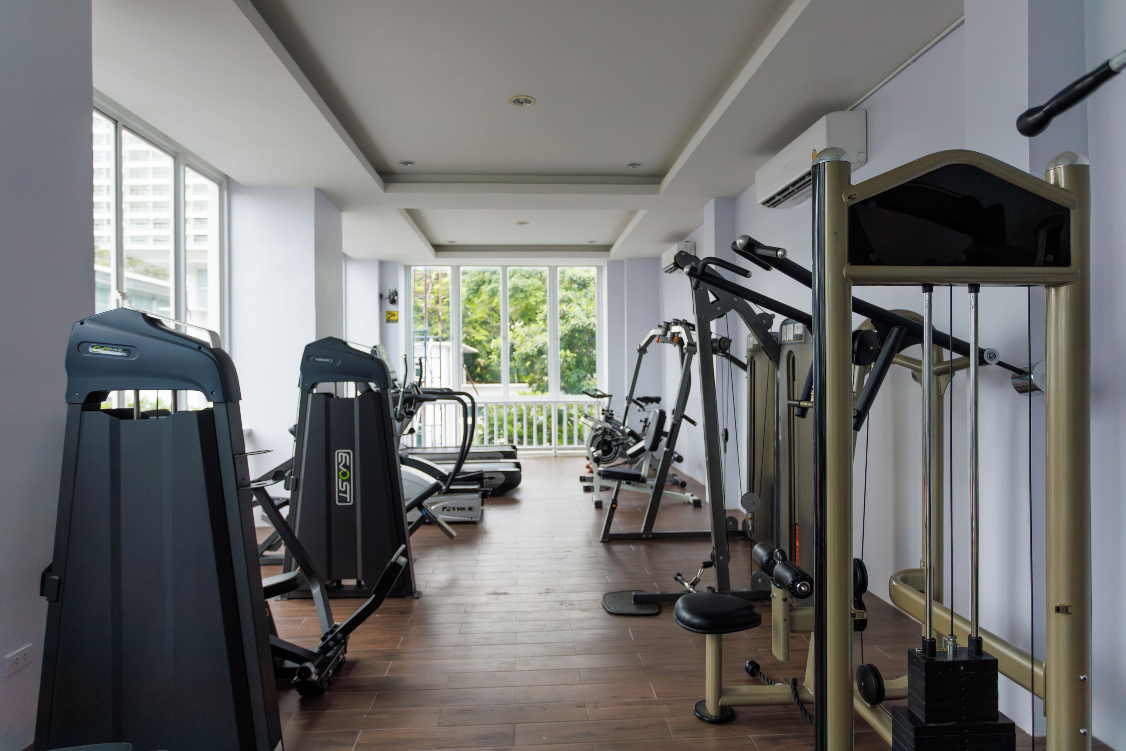 A gym with exercise machines, a treadmill, and a bench.