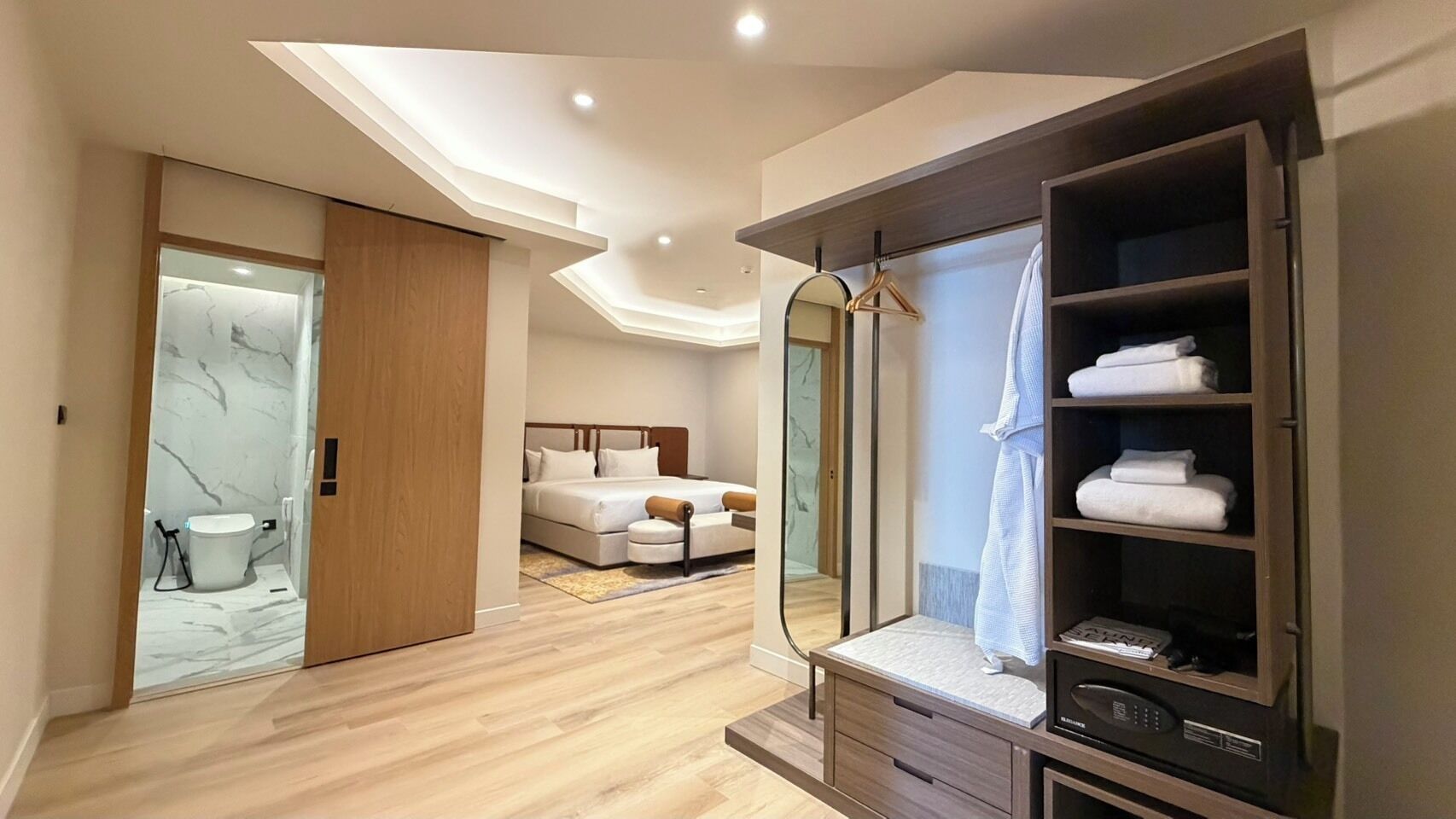 Un dormitorio moderno con cama, mesita de noche y un vestidor con estantes.