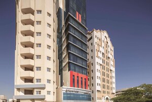 Un hotel con varios pisos, balcones y una fachada llamativa en rojo y negro.