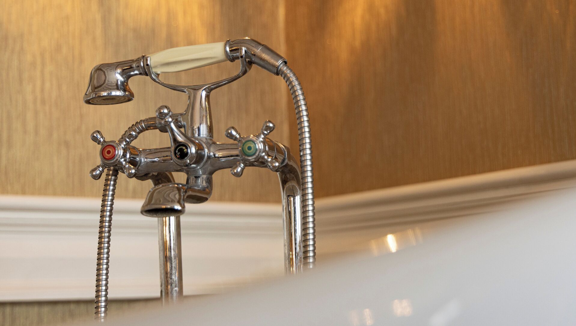 Un baño con grifo cromado, cabezal de ducha y ducha de mano.