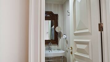A bathroom with a white sink, mirror, and towel rack.