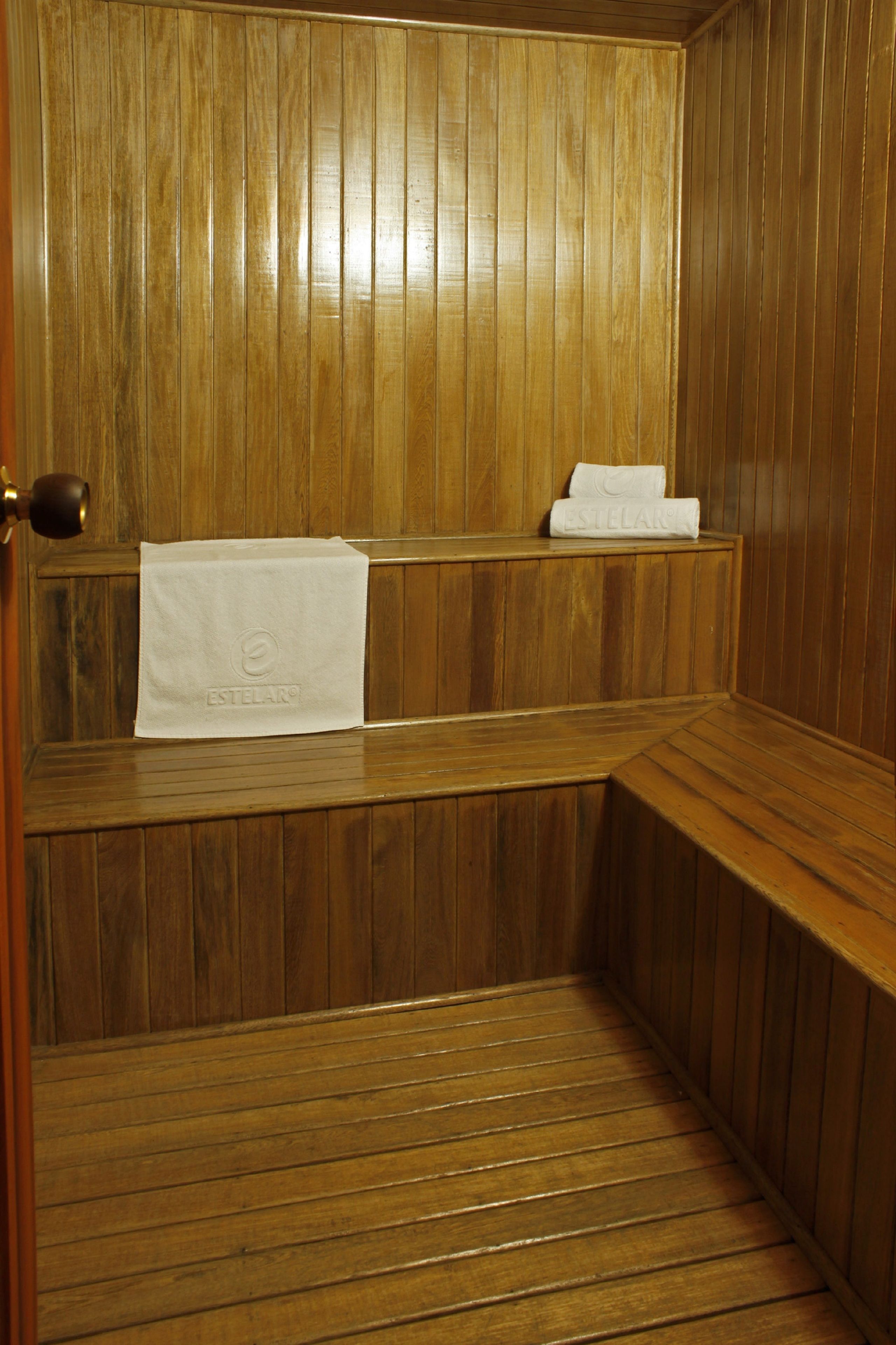 Una sauna de madera con bancos y un perchero para toallas.