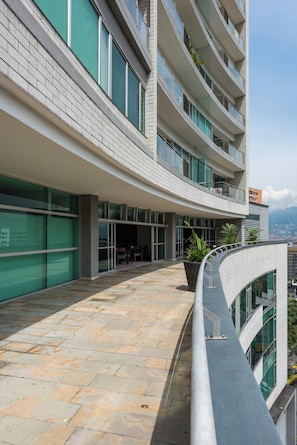 A modern building with a curved balcony, large windows, and a stone-paved walkway. - Estelar Apartamentos Medellin (Medellín)