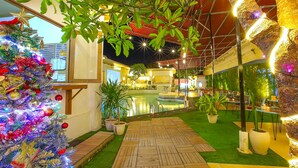 An indoor area with a Christmas tree, a pool, and potted plants. - Lavender Villa and Spa (Kuta)