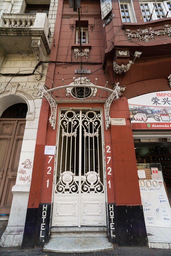 Entrada de hotel con puertas de metal ornamentadas y el número 721.