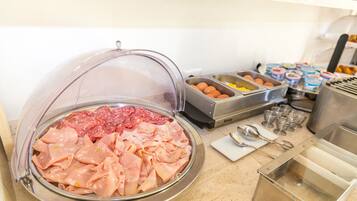 A buffet with various food options including meats, eggs, and yogurt.