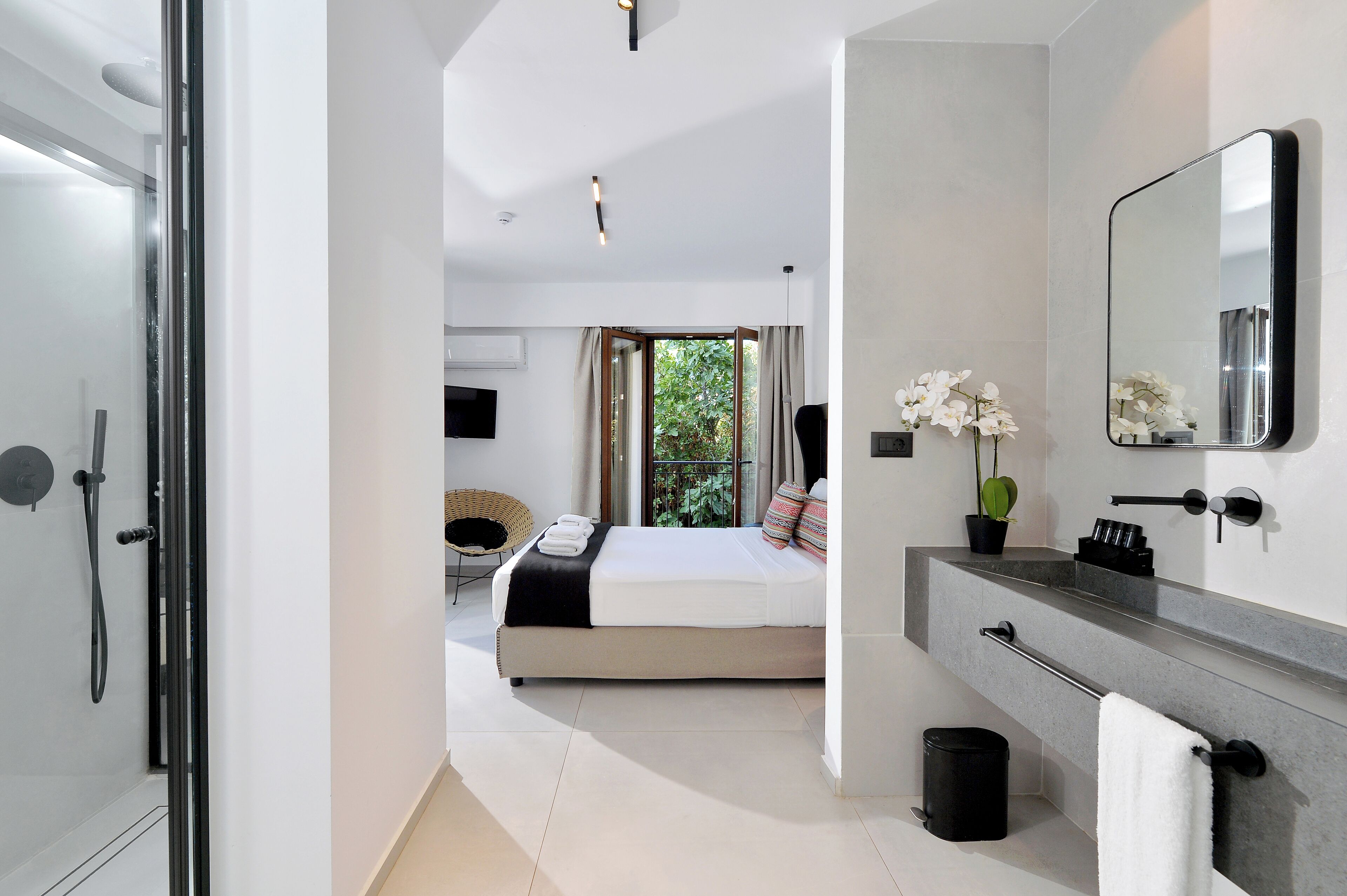 Un baño moderno con un espejo grande, un perchero y un lavabo.