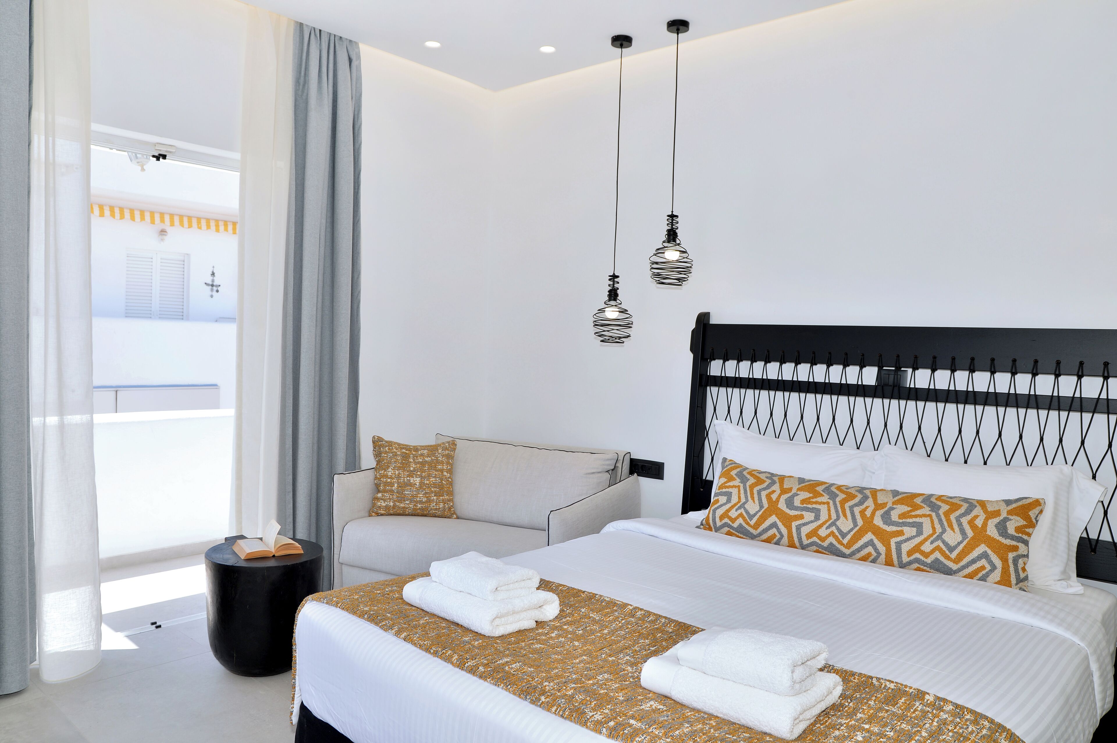 Un hotel moderno con una cama grande, un sofá y vistas al exterior.