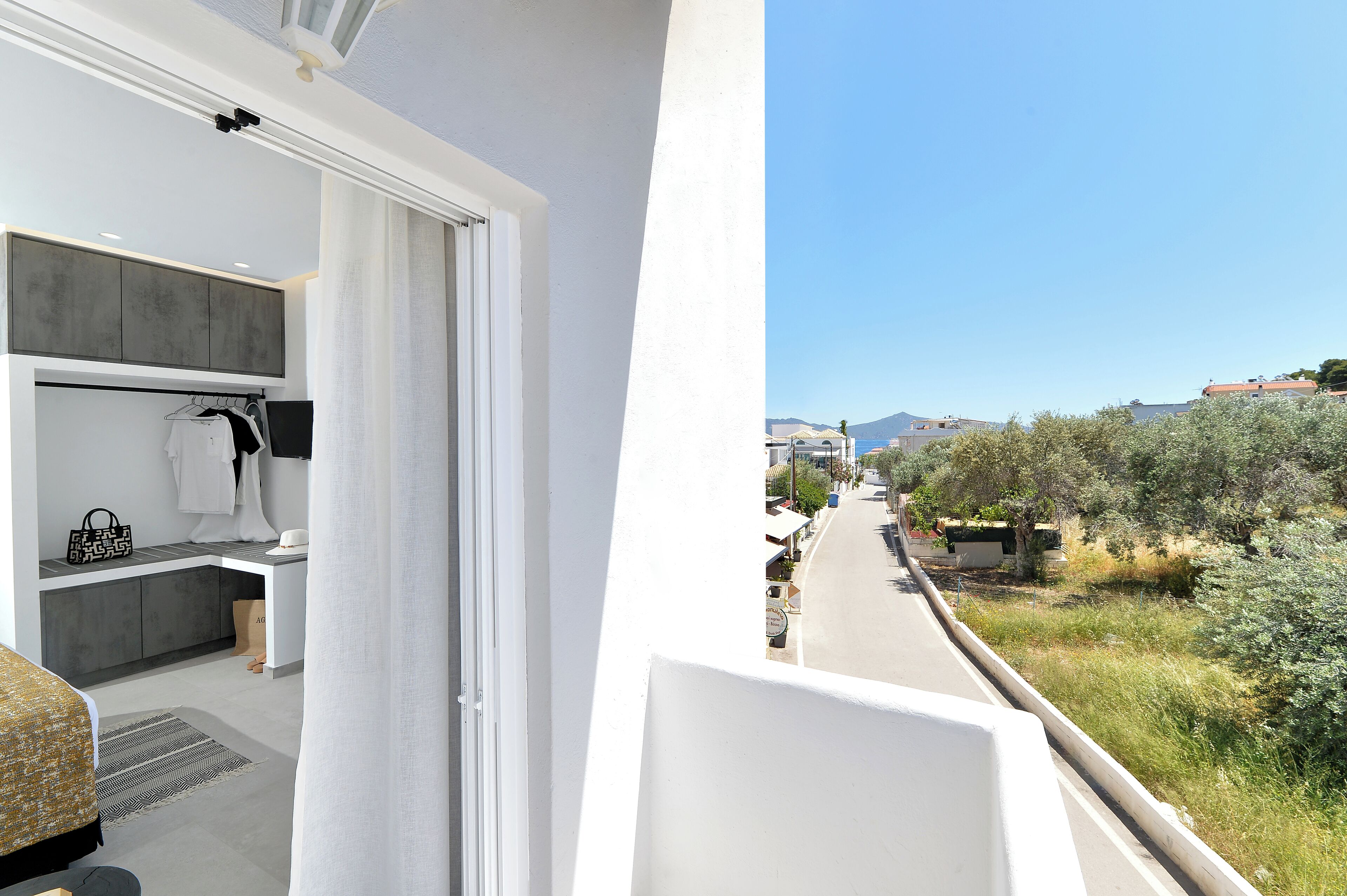 A balcony with a view of a street and mountains.