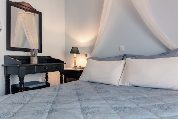 A bedroom with a bed, a nightstand, a dresser, a mirror, and a lamp. - Hotel Yianna (Agistri)