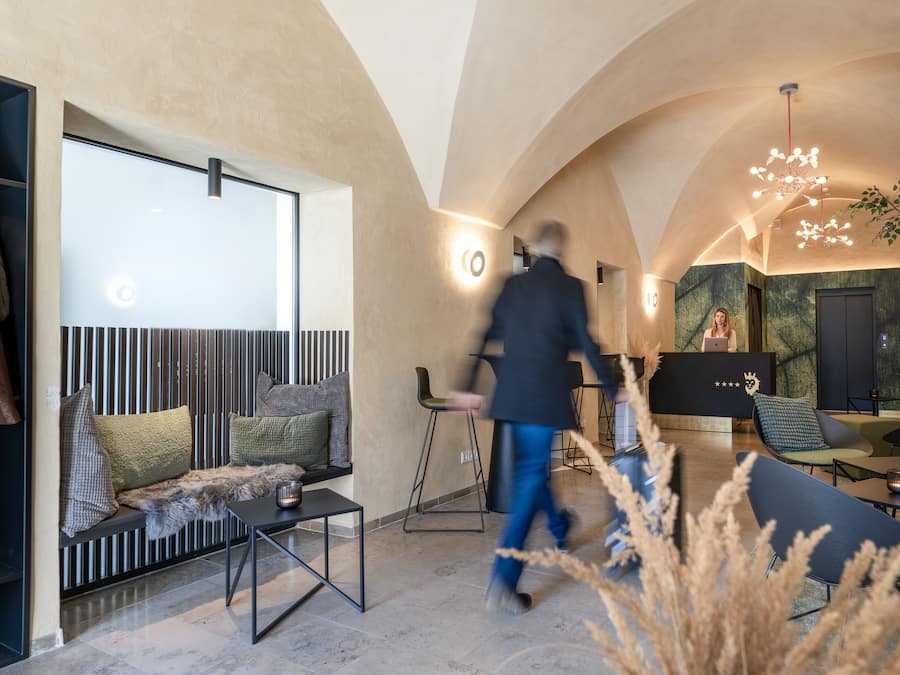 Un interior moderno con una zona de estar, un mostrador de recepción y una escalera.