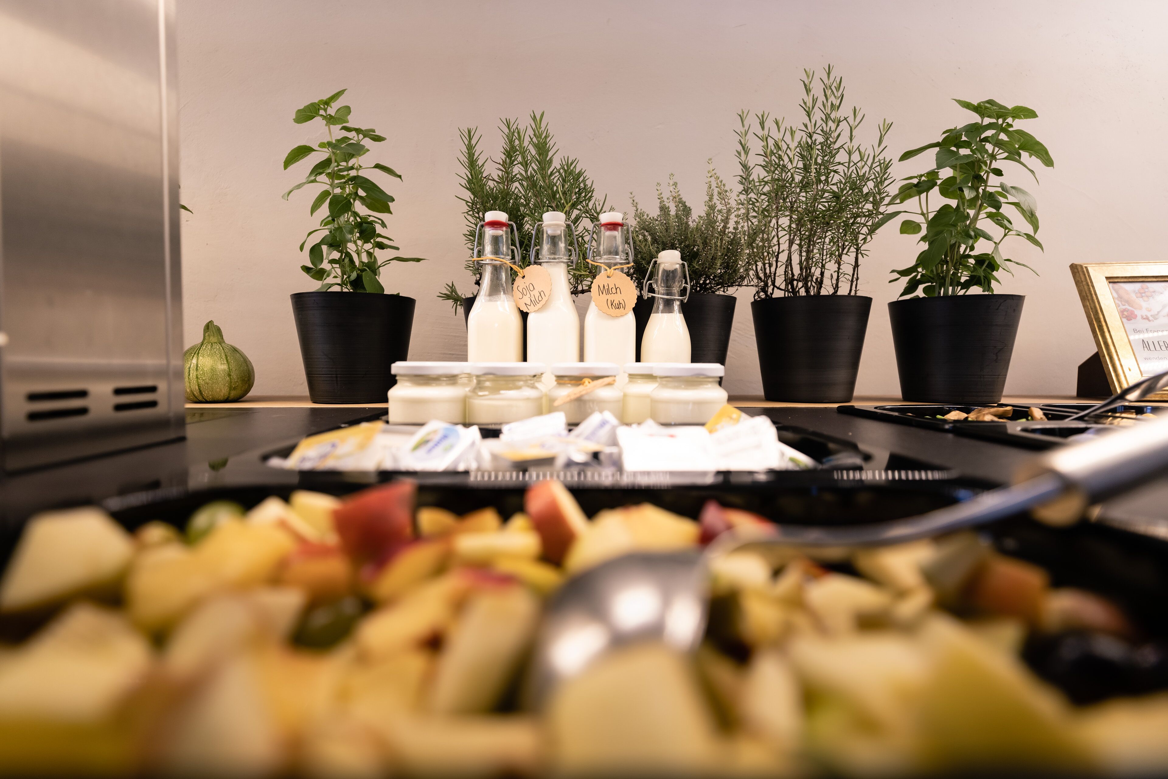 A kitchen counter with various food items and bottles labeled with names like "Soya Milk" and "Mochi."