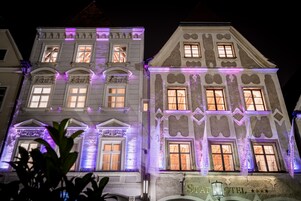 Un edificio histórico con ventanas iluminadas y un letrero que dice "Stad Hotel".