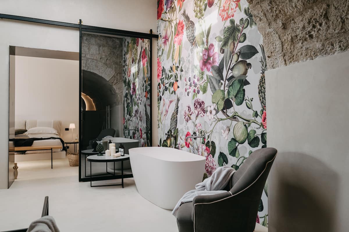 A modern bathroom with a freestanding bathtub, a vanity with a mirror, and a shower area.