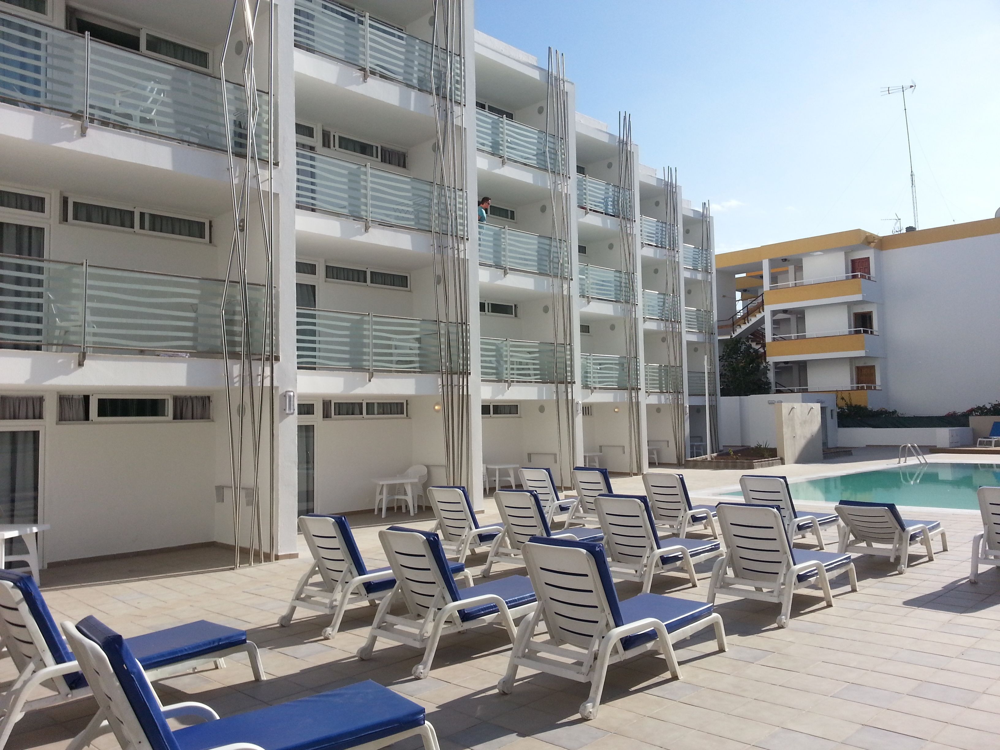 Un espace aménagé au bord de la piscine, avec des chaises longues et une piscine.
