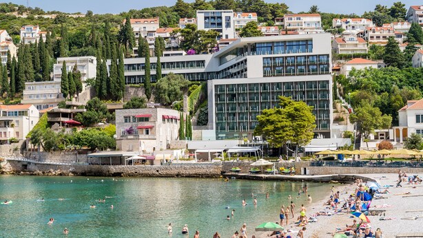 A coastal town with a beach, buildings, and a clear view of the sea.