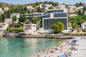 Un pueblo costero con playa, edificios y una vista despejada del mar.
