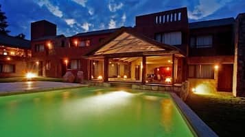 Una piscina al aire libre, sillones reclinables de piscina