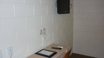 A small office with a desk, chair, telephone, and a mounted computer monitor.