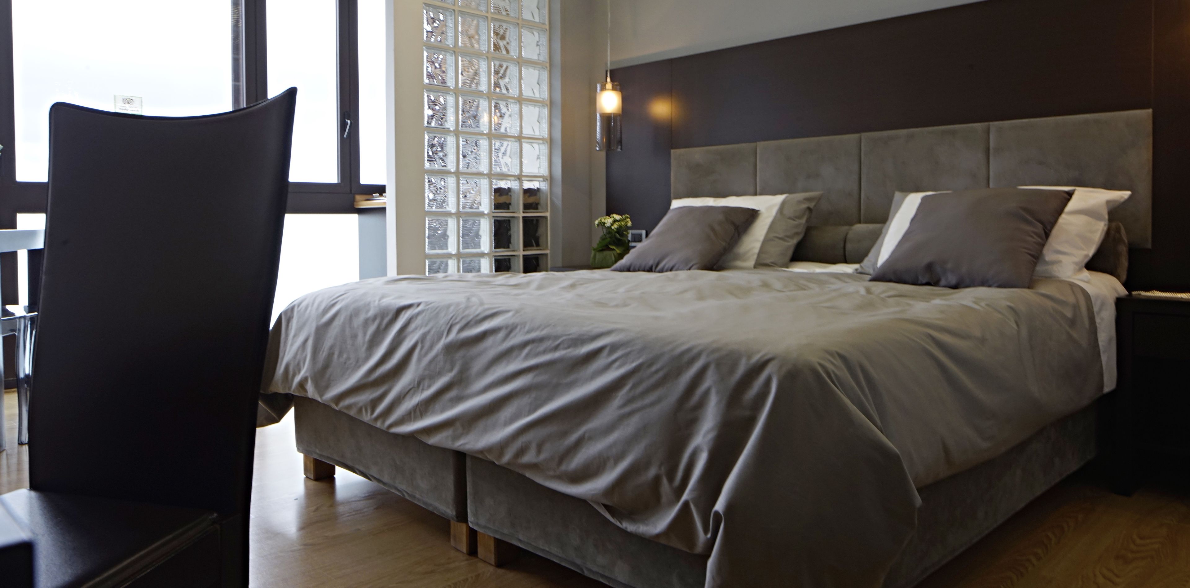 Una camera da letto con un letto grande, un comodino e una sedia.