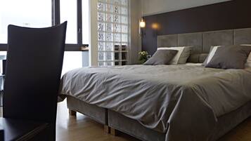 Una camera da letto con un letto grande, un comodino e una sedia.