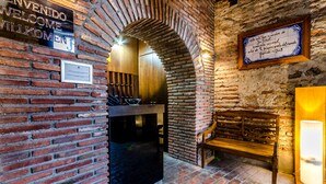 Interior de paredes de ladrillo con un banco de madera y un cartel que dice 'Welcome'.