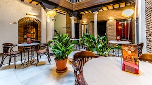 Un café acogedor con paredes de ladrillo, muebles de madera y plantas en macetas.