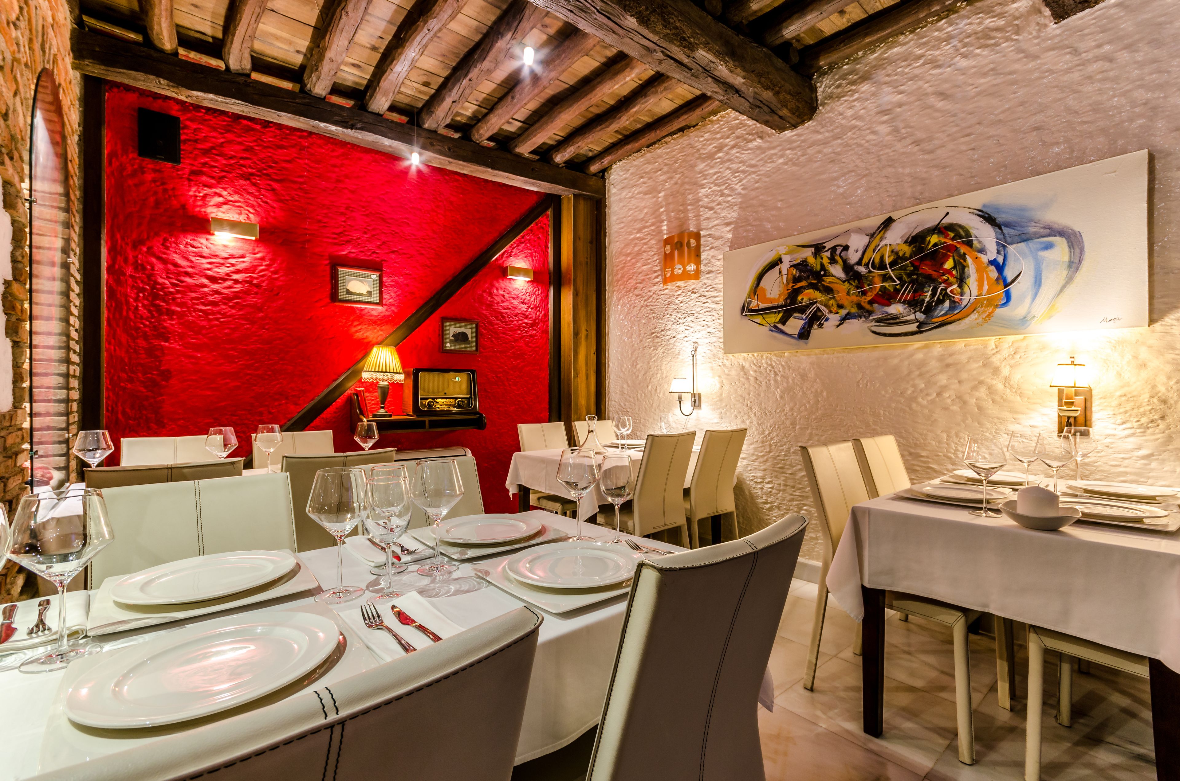 A restaurant with red walls, white tables, and modern decor.