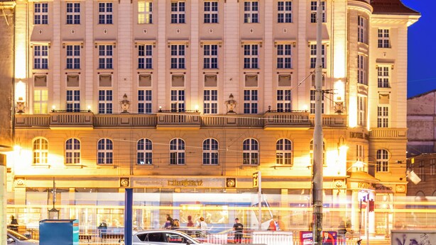 Un hotel grande e histórico con un letrero destacado que dice 