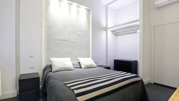 Un dormitorio moderno con cama, mesitas de noche y un armario.