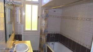 Un baño con lavabo, espejo y bañera.