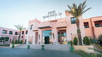 Ein Hotel Eingang mit einem Schild, das 'Zalagh Kasbah Hotel & Spa' zeigt, im traditionellen Architekturstil, und einer gepflasterten Auffahrt mit Stufen zum Eingang.