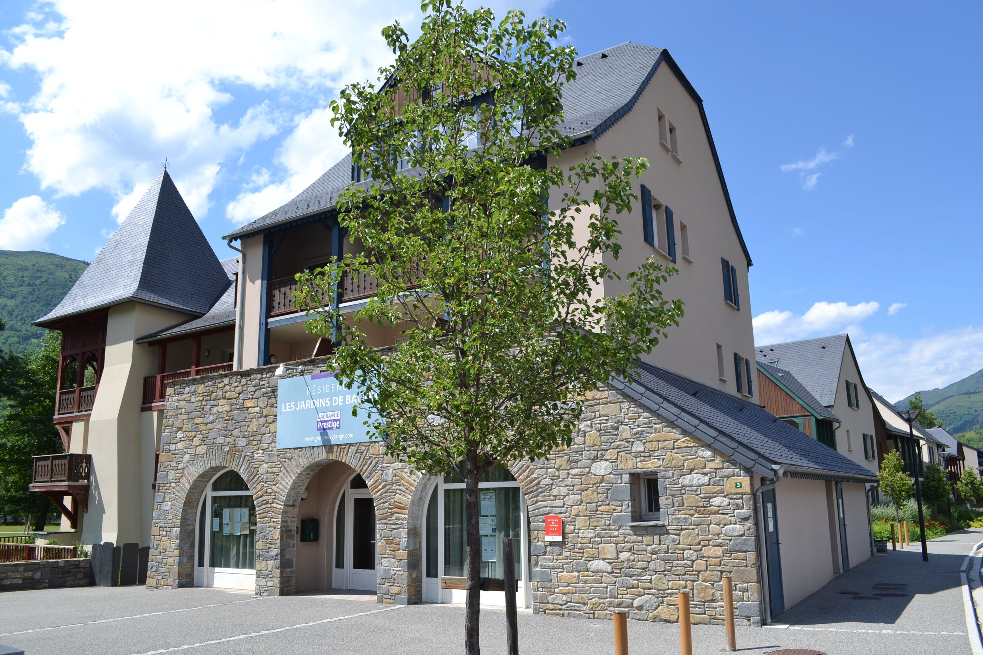 Un hotel con fachada de piedra, un balcón y un letrero que indica que es un restaurante.