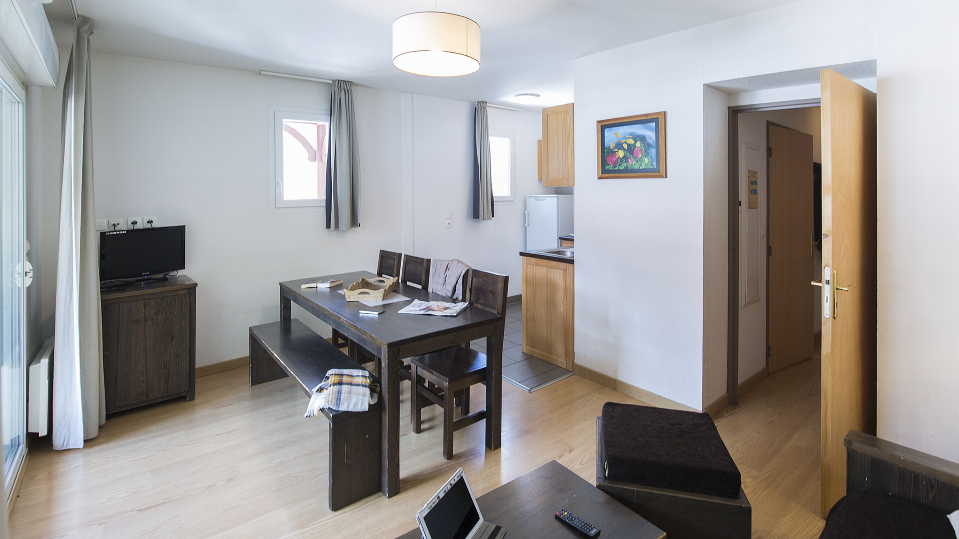 Un appartement moderne comprenant un coin repas, une kitchenette et un salon.