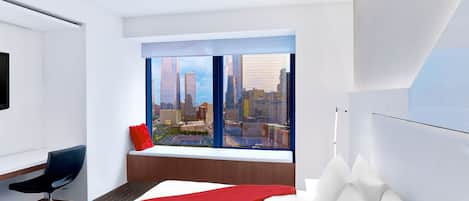 Quarto de hotel moderno com uma grande janela que oferece vista da cidade, uma cama com roupa de cama branca, um cobertor vermelho e uma escrivaninha com cadeira.