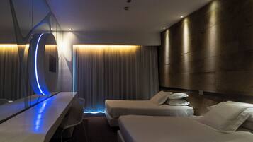 Ein modernes Hotelzimmer mit einem Bett, Nachttischen, einem Schreibtisch und einem großen Spiegel.
