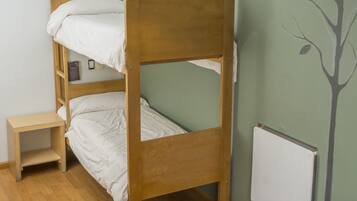 A bunk bed room with a wooden headboard, a bedside table, and a hanging lamp.