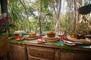 A buffet table with various desserts and tropical decorations. - ThalassaGarden Hotel - Pousada (Tibau do Sul)